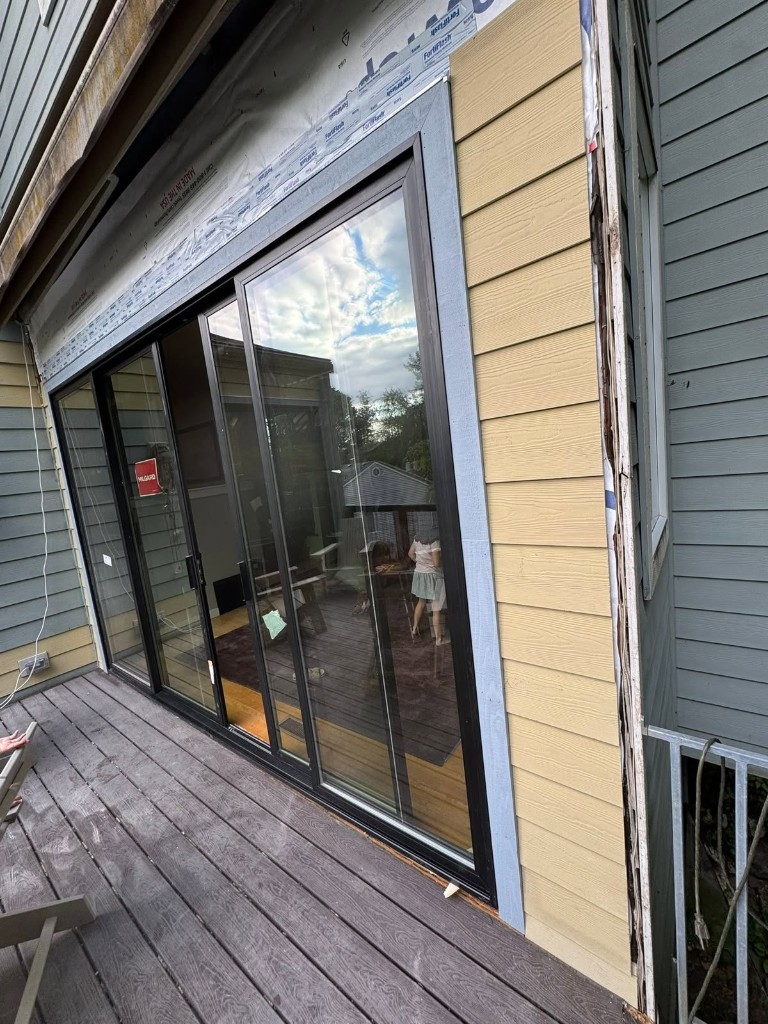 Milgard sliding glass door installation with new siding in progress